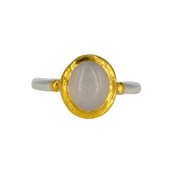 Deze ring heeft een scheen van zilver die 2,5 mm dik is. De steen is gezet in 24 karaat goud en heeft een gouden bolletje aan weerszijde.